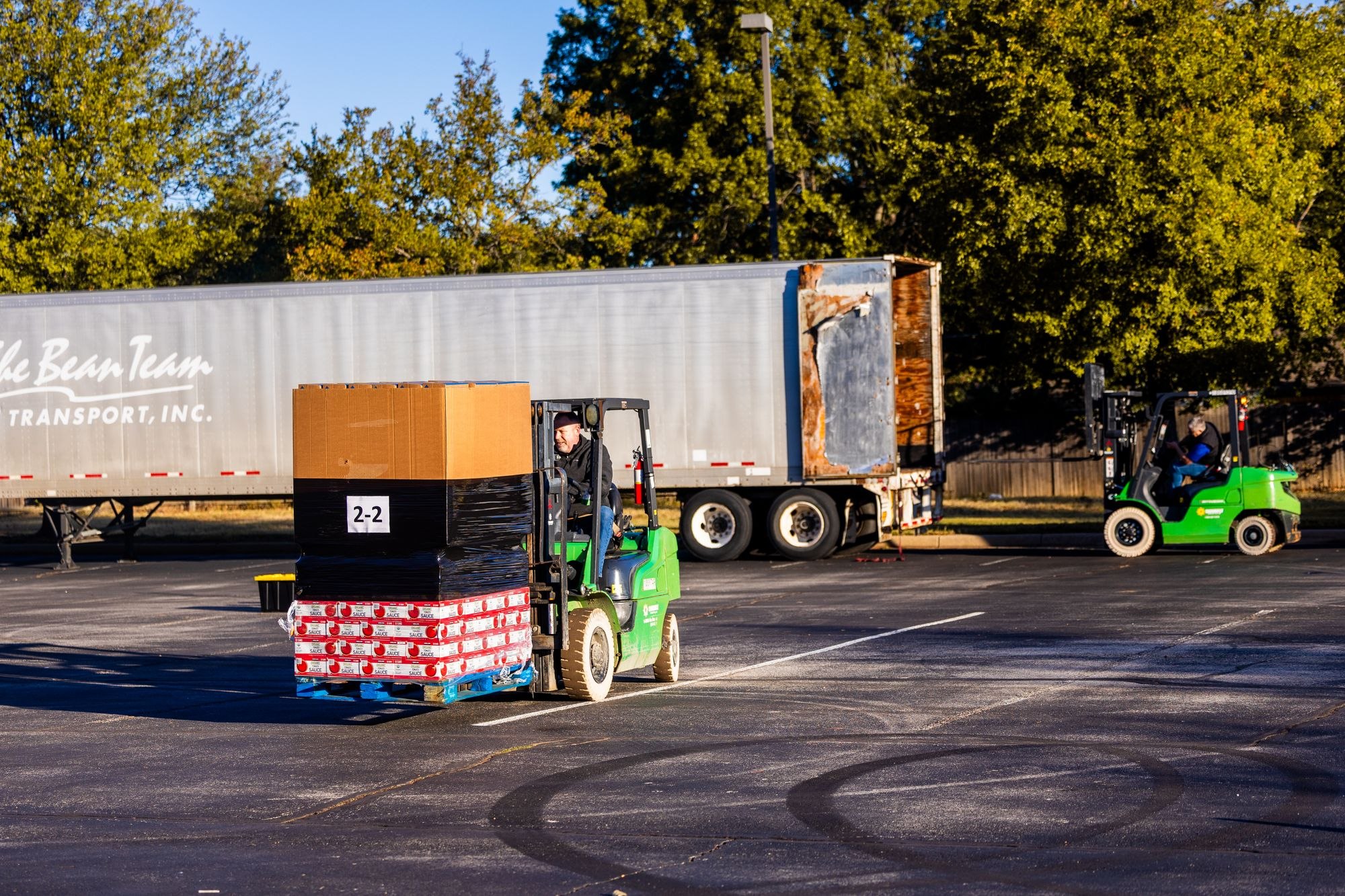 Forklift operators loading palletized freight onto a truck
