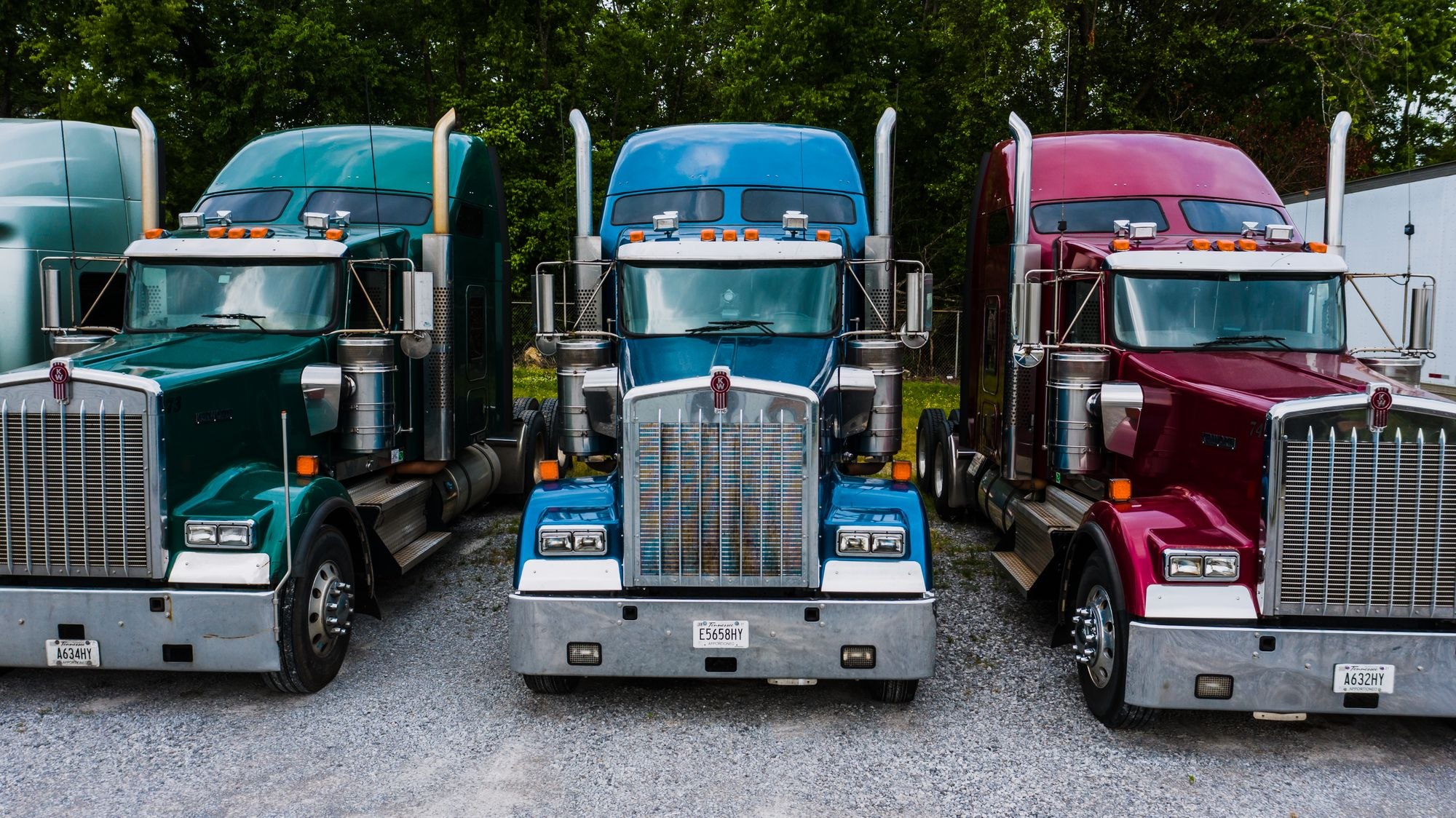Conventional American semi trucks parked in a freight yard